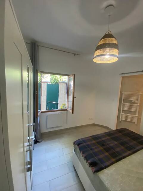 Chambre avec lit double et fenêtre ouverte